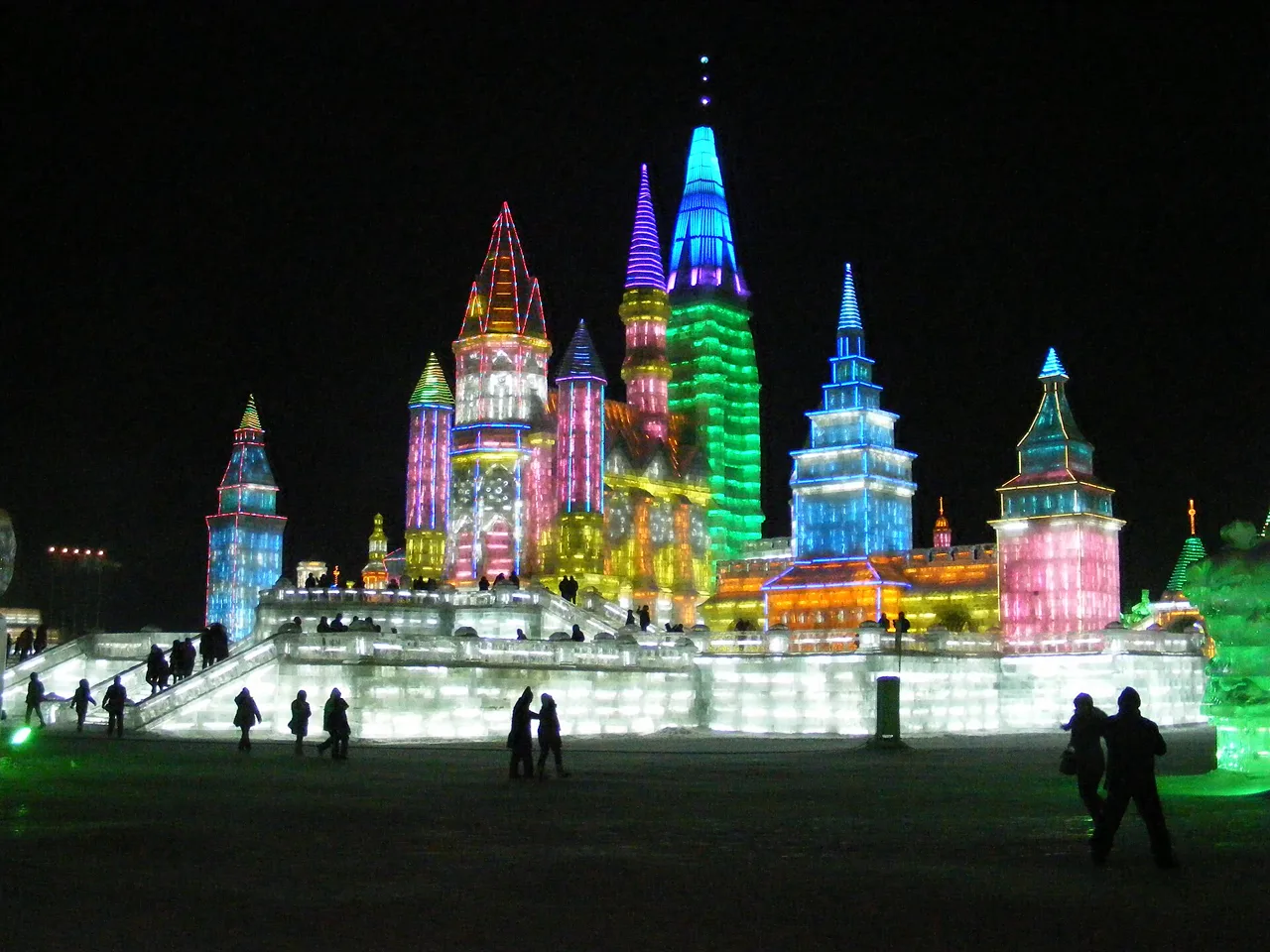 Illuminated ice towers rising above visitors at Harbin Ice and Snow World
